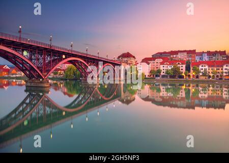 Maribor, Slowenien. Stadtbild von Maribor, Slowenien bei schönem Sommersonnenaufgang mit Spiegelung der Stadt in der Drau. Stockfoto