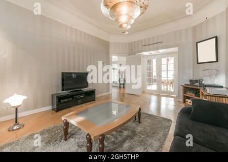 Die Einrichtung der modernen geräumigen Lounge mit komfortablen Möbeln in der neuen Wohnung Stockfoto