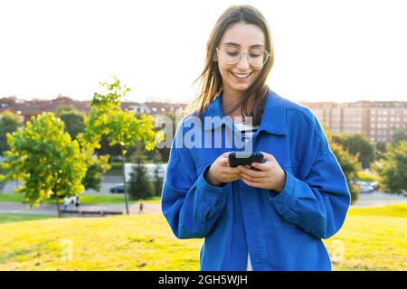 Junge schwarze Ärztin in einem medizinischen Mantel und einer Brille mit Stethoskop, die mit einer Tablette in einem modernen Klinikbüro arbeitet Stockfoto