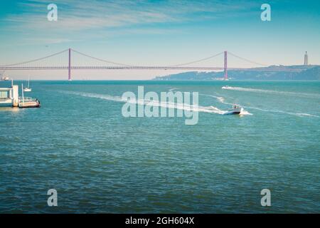 Drohnenansicht des modernen Kais in der Nähe des Uferdamms an der Küste des Flusses Tejo in der Nähe des Torre de Belem-Gartens und nicht weit von der Brücke 25 de Abril am Tag Stockfoto