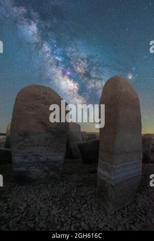 Malerischer Blick auf das spanische Stonehenge auf unwegsamem Gelände unter dem Sonnenuntergangshimmel mit Galaxie in Caceres Spanien Stockfoto