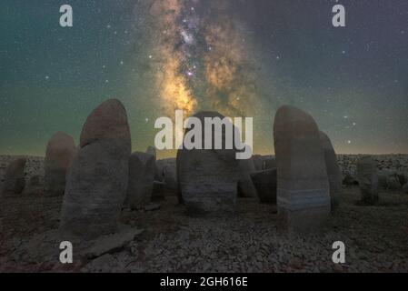 Malerischer Blick auf das spanische Stonehenge auf unwegsamem Gelände unter dem Sonnenuntergangshimmel mit Galaxie in Caceres Spanien Stockfoto