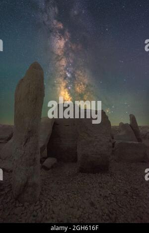 Malerischer Blick auf das spanische Stonehenge auf unwegsamem Gelände unter dem Sonnenuntergangshimmel mit Galaxie in Caceres Spanien Stockfoto