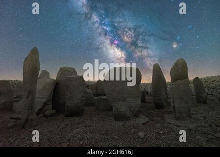 Malerischer Blick auf das spanische Stonehenge auf unwegsamem Gelände unter dem Sonnenuntergangshimmel mit Galaxie in Caceres Spanien Stockfoto