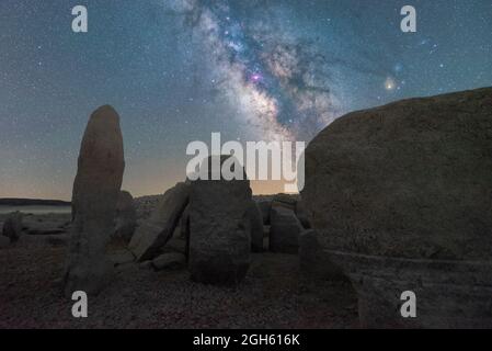 Malerischer Blick auf das spanische Stonehenge auf unwegsamem Gelände unter dem Sonnenuntergangshimmel mit Galaxie in Caceres Spanien Stockfoto