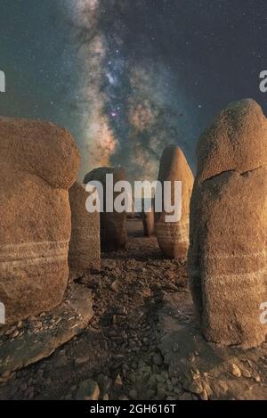 Malerischer Blick auf das spanische Stonehenge auf unwegsamem Gelände unter dem Sonnenuntergangshimmel mit Galaxie in Caceres Spanien Stockfoto