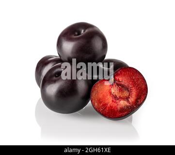 Haufen von ganzen schwarzen Pflaumen und einer saftigen Hälfte isoliert auf weißem Hintergrund. Frische reife süße Pflaumen sind bereit zu essen. Vegetarisch vegan Vitamin essen. Stockfoto