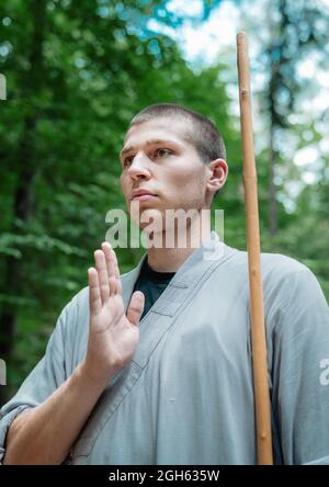 Niedriger Winkel des Mannes, der die Hand in der Nähe der Brust hält, während er im Wald Kung Fu übt Stockfoto