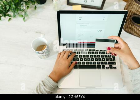 Crop unkenntlich weiblich machen Kauf mit Plastikkarte für die Bestellung während Online-Shopping über Laptop Stockfoto