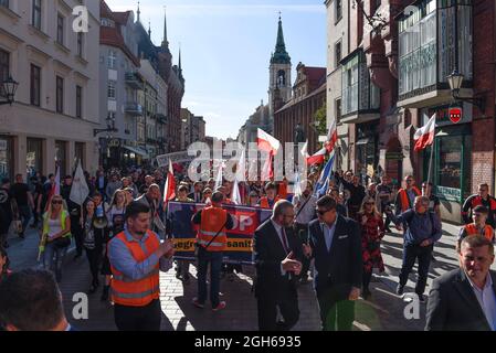 Torun, Polen, Polen. September 2021. Während eines Anti-vax-Protestes am 5. September 2021 in Torun, Polen, marschieren Menschen mit polnischen Fahnen durch die Altstadt. Einige hundert Personen nahmen an einer Kundgebung Teil, die von der Partei der rechtsextremen Konföderation (Konfederacja) gegen obligatorische Impfstoffe, die Einführung des grünen COVID-19-Zertifikats, bekannt als Green Pass, und die Beschränkungen, die eingeführt wurden, um die Ausbreitung des SARS-CoV-2 Coronavirus einzudämmen. (Bild: © Aleksander Kalka/ZUMA Press Wire) Stockfoto