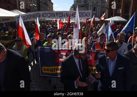 Torun, Polen, Polen. September 2021. Während eines Anti-vax-Protestes am 5. September 2021 in Torun, Polen, marschieren Menschen mit polnischen Fahnen durch die Altstadt. Einige hundert Personen nahmen an einer Kundgebung Teil, die von der Partei der rechtsextremen Konföderation (Konfederacja) gegen obligatorische Impfstoffe, die Einführung des grünen COVID-19-Zertifikats, bekannt als Green Pass, und die Beschränkungen, die eingeführt wurden, um die Ausbreitung des SARS-CoV-2 Coronavirus einzudämmen. (Bild: © Aleksander Kalka/ZUMA Press Wire) Stockfoto