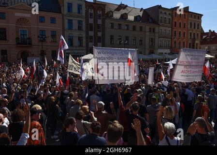 Torun, Polen, Polen. September 2021. Während eines Anti-vax-Protestes am 5. September 2021 in Torun, Polen, halten Menschen Transparente und schwenken polnische Fahnen. Einige hundert Personen nahmen an einer Kundgebung Teil, die von der Partei der rechtsextremen Konföderation (Konfederacja) gegen obligatorische Impfstoffe, die Einführung des grünen COVID-19-Zertifikats, bekannt als Green Pass, und die Beschränkungen, die eingeführt wurden, um die Ausbreitung des SARS-CoV-2 Coronavirus einzudämmen. (Bild: © Aleksander Kalka/ZUMA Press Wire) Stockfoto