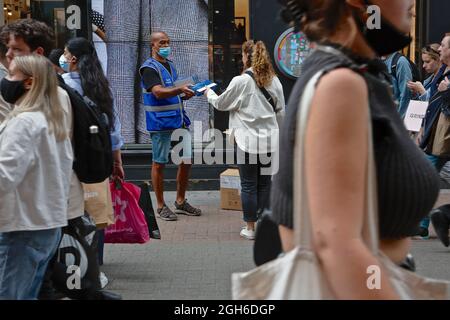 London (UK), 28. August 2021: Ein NHS-Mitarbeiter gibt in der Carnaby Street in London frre Rapid covid Testkits an die Öffentlichkeit. Stockfoto