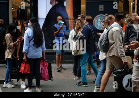 London (UK), 28. August 2021: Ein NHS-Mitarbeiter gibt in der Carnaby Street in London frre Rapid covid Testkits an die Öffentlichkeit. Stockfoto