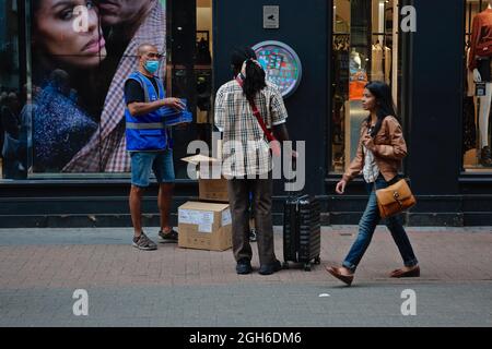 London (UK), 28. August 2021: Ein NHS-Mitarbeiter gibt in der Carnaby Street in London frre Rapid covid Testkits an die Öffentlichkeit. Stockfoto