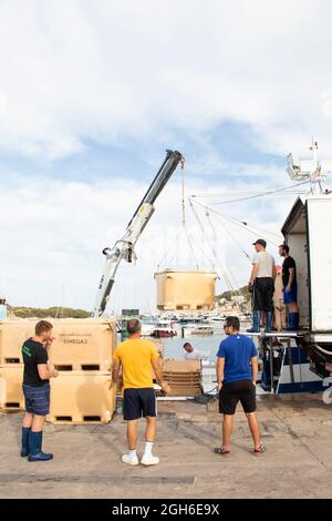 Tribunj, Kroatien - 4. August 2021: Fischer und Hafenarbeiter laden Fischcontainer in einen LKW Stockfoto