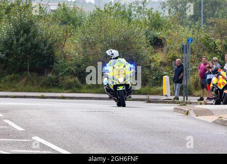 Police Motorräder, die während des Tour of Britain Cycle Race 2021 als rollende Straßensperre fungieren, als es durch Camborne in Cornwall ging. Stockfoto