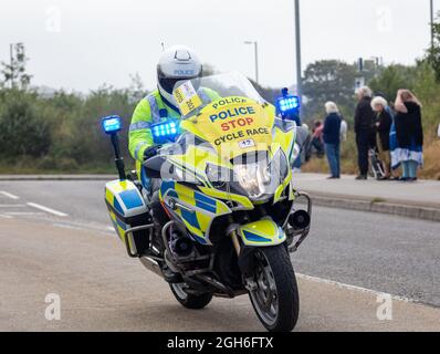 Police Motorräder, die während des Tour of Britain Cycle Race 2021 als rollende Straßensperre fungieren, als es durch Camborne in Cornwall ging. Stockfoto