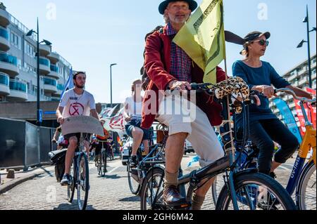 Amsterdam, Niederlande. September 2021. Während der Demonstration wird ein Aktivist auf einem Fahrrad mit einer Flagge gesehen.Aktivisten der Rebellion vom Aussterben organisierten einen Protest gegen den Grand Prix in Zandvoort als Beispiel für unnötige Emissionen und Störungen der Natur. Die Aktivisten fuhren mit ihren Fahrrädern nahe an der Rennstrecke, um die Öffentlichkeit darauf aufmerksam zu machen, dass die ökologische Krise jetzt ist und die Treibhausgasemissionen innerhalb weniger Jahre auf Null zu reduzieren. (Foto: Ana Fernandez/SOPA Images/Sipa USA) Quelle: SIPA USA/Alamy Live News Stockfoto