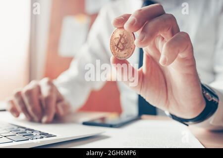 Geschäftsmann, der Bitcoin in der Hand hält, Online-Kryptowährungshandel und -Austausch, selektiver Fokus Stockfoto