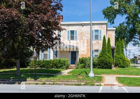 OLEAN, NY, USA-14 AUGUST 2021: Eine Residenz mit abgenutzter Stuckfassade. Stockfoto