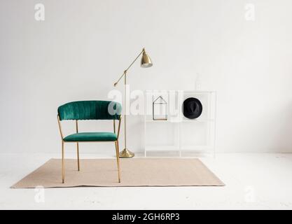 Moderne Wohnung mit Sessel gegen Kopie Raumwand im Wohnzimmer. Horizontale Ansicht von komfortablen Möbeln in minimalistischem Haus. Stilvolles Interieur Stockfoto