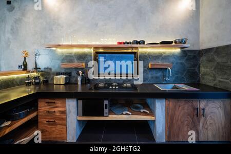 Moderne, große, luxuriöse, dunkelgraue Küche in der Nähe mit Weinflasche an der Küchentheke, unauffindmöglich. Stockfoto