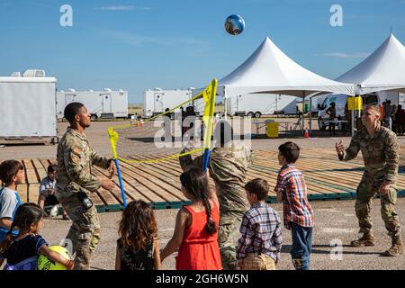 US Air Force Airmen spielen eine Partie Volleyball mit jungen afghanischen Flüchtlingen, die während ihres Aufenthalts auf der Holloman Air Force Base am 3. September 2021 in Alamogordo, New Mexico, aus Kabul evakuiert wurden. Holloman hat provisorische Unterkünfte für mindestens 50,000 afghanische Evakuierte geschaffen. Stockfoto