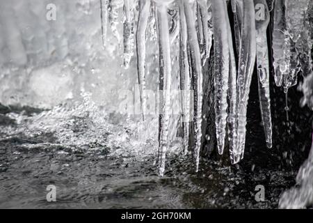 Gefrorener Wasserfall und klare Eiszapfen, an einem bitterkalten Tag im Winter Stockfoto