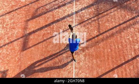 Blick von oben auf einen Mann, der Paddle-Tennis auf einem Platz im Freien spielt. Paddel- oder Matchübungen. Stockfoto