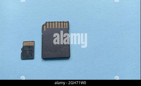 Zwei große und kleine Speicherkarten in Schwarz auf blauem Hintergrund mit Copyspace Stockfoto