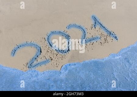 2021 Zeichen und Symbol geschrieben Text auf dem Strand Sand Wort. Stockfoto