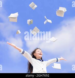 Glücklich freundliches Mädchen Student werfen Bücher fliegen in der Luft Stockfoto