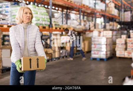 Müde Frau, die Kisten trägt Stockfoto