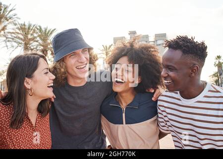 Eine Gruppe von jungen Jungen und Mädchen verschiedener Nationalitäten umarmen sich gerne gegenseitig. Nettes Lächeln von schönen Menschen. Stockfoto