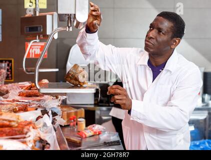 Verkäufer wiegt Staus auf Waage Stockfoto