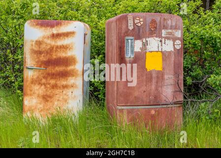 Zwei rostige Vintage-Kühlschränke wurden draußen auf den Prärien aufgegeben Stockfoto