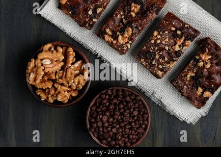 Schokoladenbrownie neben Walnüssen und Pralinen in Tontöpfen Stockfoto