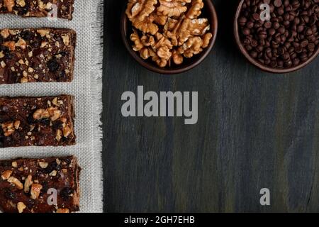 Stücke von Schokolade Brownie neben Walnüssen und Schokolade in Tontöpfen Stockfoto