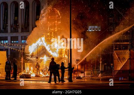 Feuerwehrleute kontrollieren das Stadtfeuer von La Falla, das in der Nacht von La Crema auf der Plaza del Ayuntamiento in Valencia brennt. La Crema ('verbrannt') ist der Akt des Feuers auf Karton- oder Holzdenkmäler (in diesem Fall die Fallas) während der Feierlichkeiten in verschiedenen Städten der Valencianischen Gemeinschaft (Spanien). Mit der Verbrennung der Denkmäler markiert es das Ende des Festivals. Die Fallas, das berühmteste Fest in Valencia, wird vom 1. Bis 5. September 2021 mit Einschränkungen aufgrund der durch Covid19 verursachten Pandemie gefeiert. (Foto von Xisco Navarro/SOPA Images/Sipa USA) Stockfoto