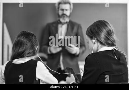 ebook Konzept. Hausaufgaben schreiben und lesen. Kinder Mädchen und Lehrer Mann. Grundschullehrer Gibt Unterstützung Im Klassenzimmer. Pupille Stockfoto