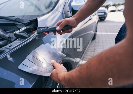 Person mit Schattierungen Karten von Grau für die Auswahl der Farbe Auto Stockfoto