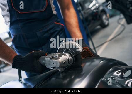 Reparaturman arbeitet mit Seitenschleifer am Auto Detail Stockfoto