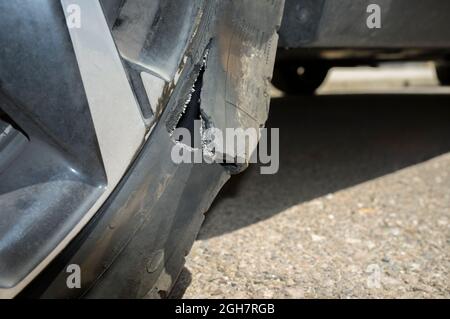 Autorad mit einem Platten Reifen auf der Straße nach dem Ausblasen. Nahaufnahme Stockfoto