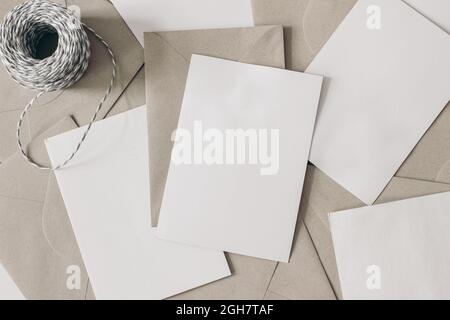 Stapel leerer Briefe mit Bastelumschlägen und dekorativem Seil auf dem Tisch. Nahaufnahme von leeren Grußkarten, Einladungen. Schreibwaren-Modelle. Post Stockfoto