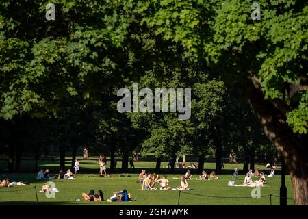 Menschen genießen die Sonne an einem ungewöhnlich heißen Tag im Frogner Park in Oslo, Norwegen Stockfoto