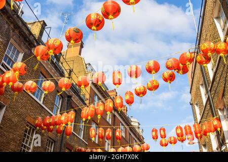 Farbenfrohe chinesische Laternen in Rot und Gold, die über die Lisle Street in Chinatown im West End von London, W1-Bezirk der City of Westminster, aufgereiht sind Stockfoto