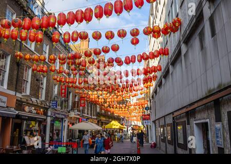 Farbenfrohe chinesische Laternen in Rot und Gold, die über die Lisle Street in Chinatown im West End von London, W1-Bezirk der City of Westminster, aufgereiht sind Stockfoto