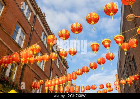 Farbenfrohe chinesische Laternen in Rot und Gold, die über die Lisle Street in Chinatown im West End von London, W1-Bezirk der City of Westminster, aufgereiht sind Stockfoto