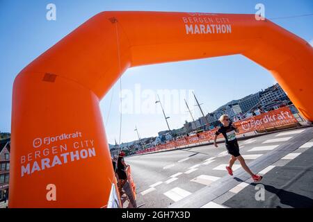 Junge Frau überquerte die Ziellinie beim Bergen City Marathon 2021 in Bergen, Norwegen, Europa Stockfoto